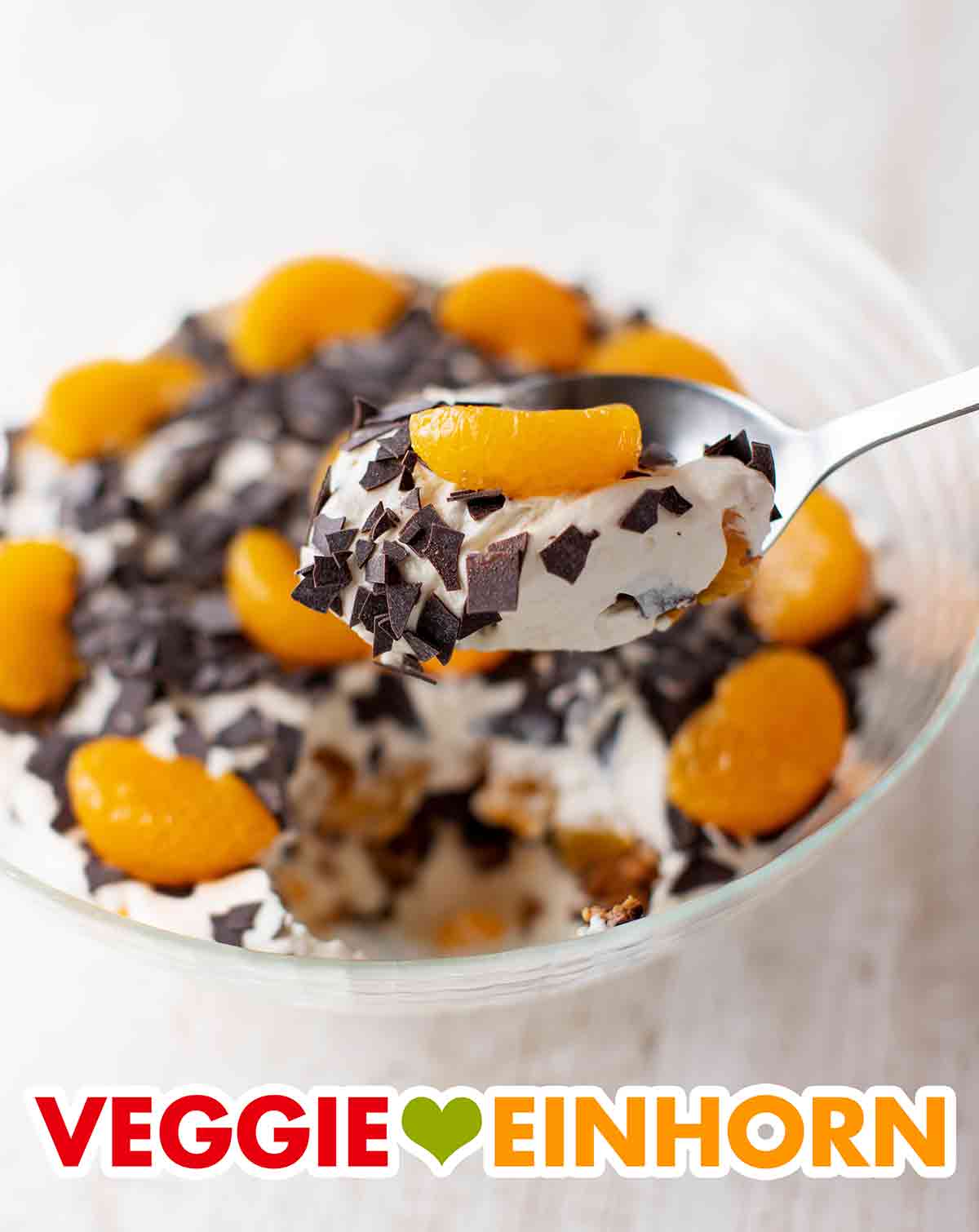 Das weihnachtliche vegane Dessert ist sehr beliebt bei Gästen. Veganer Weihnachtsnachtisch mit Mandarinen und Lebkuchen auf einem Servierlöffel