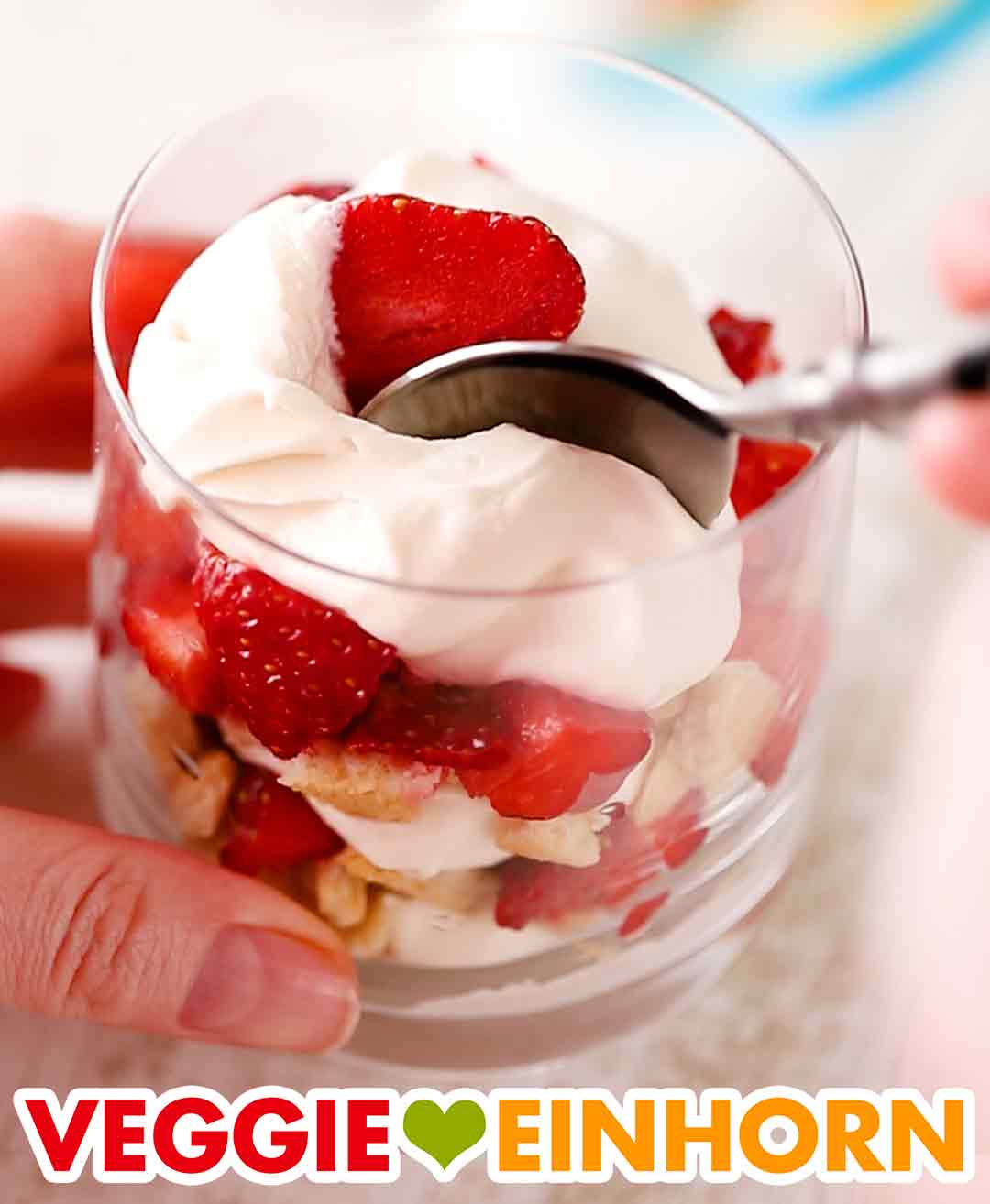 Das schnelle vegane Dessert mit Erdbeeren ist einfach und lecker. Veganer Nachtisch mit Erdbeeren im Glas mit einem Löffel