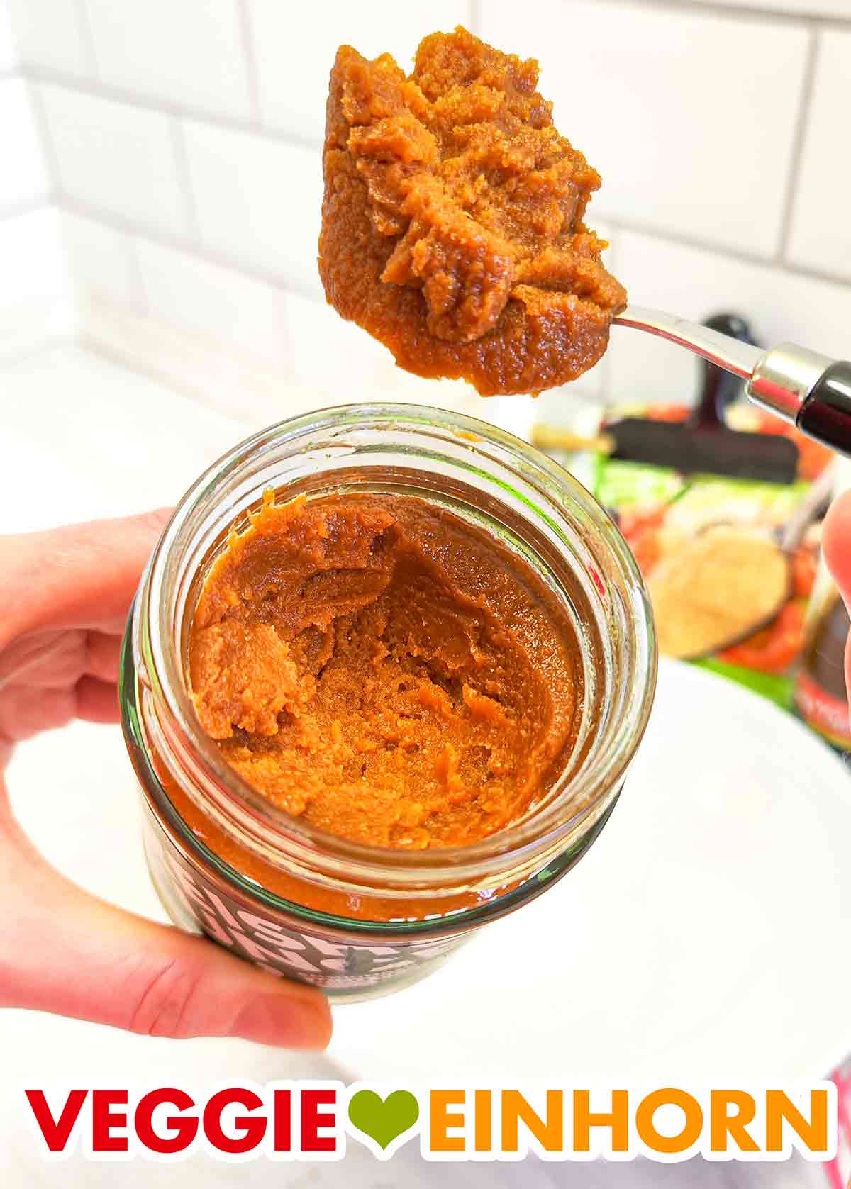 Das Shiro Miso von Reishunger ist eine hellbraune Paste. Löffel mit Reishunger Shiro Miso Paste und Misopaste im offenen Glas