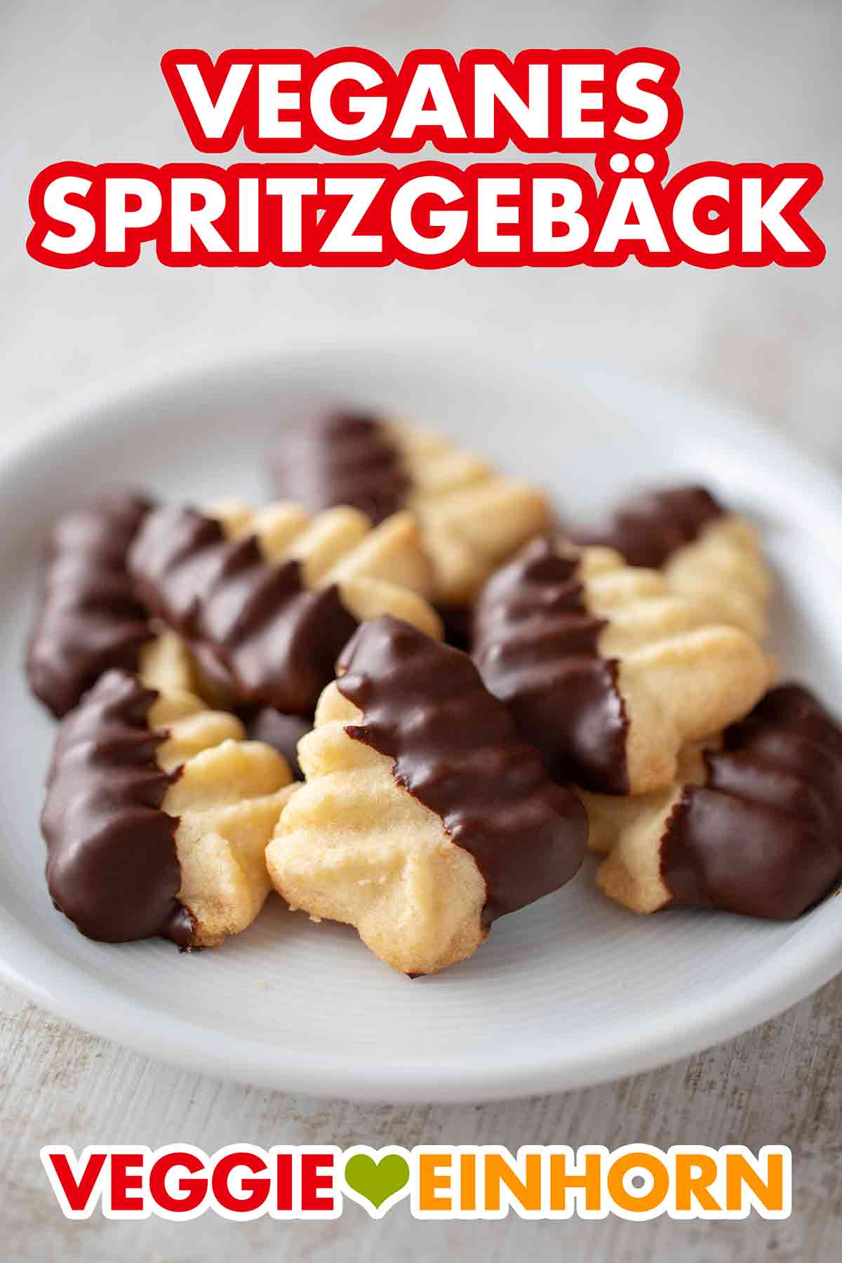 Du kannst das Spritzgebäck mit veganer Kuvertüre überziehen. Veganes Spritzgebäck mit Schokoglasur