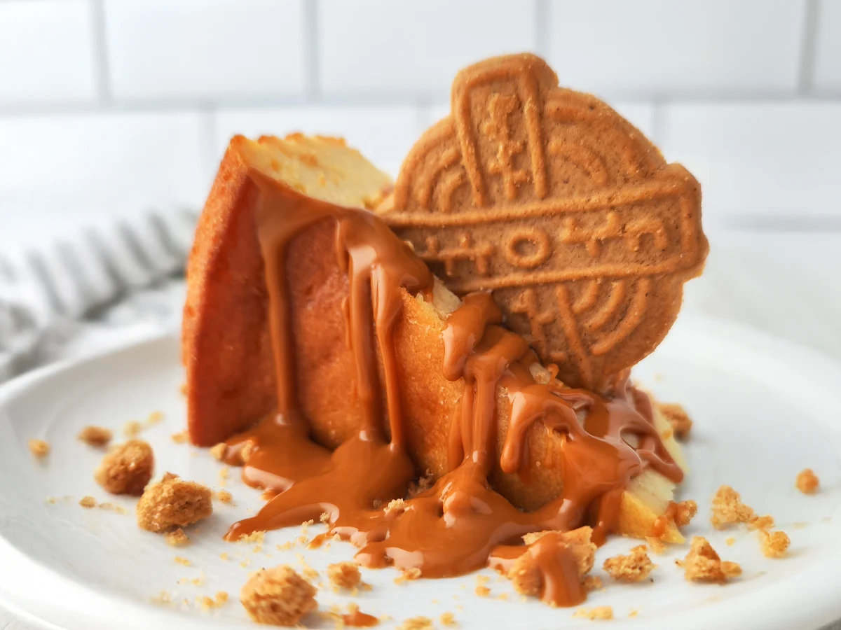 Veganes Weihnachtsdessert bestehend aus Käsekuchen mit Lotus Biscoff Creme und Spekulatius auf einem weißem Teller.
