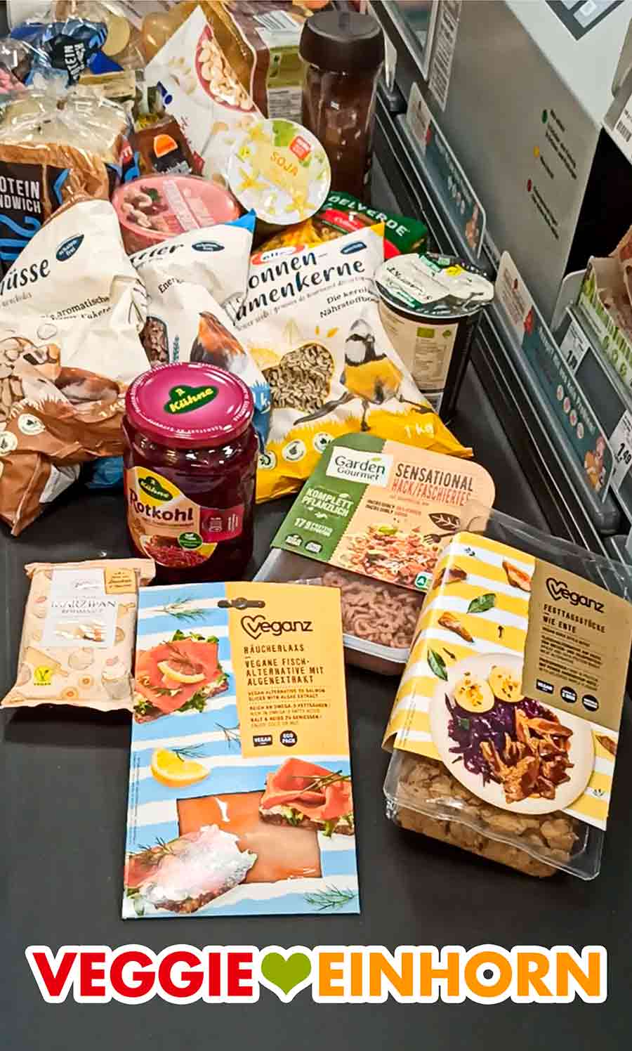 Ich habe die Veganz Ente bei Rewe gekauft. Verschiedene vegane Produkte auf dem Kassenband im Supermarkt