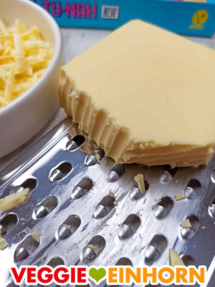 Der vegane Gouda Käse von Veganz auf einer Reibe Veganz Käseblock auf einer Reibe