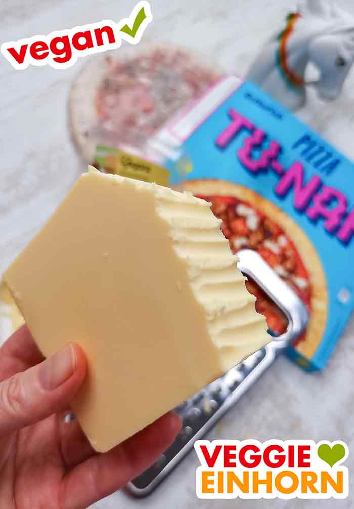 Das Veganz Genießerstück wird gerieben Der vegane Gouda Käse Block wird gerieben