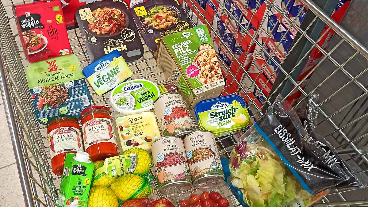 Einkaufswagen mit veganen Lebensmitteln und einem veganen Gouda Käse Block.