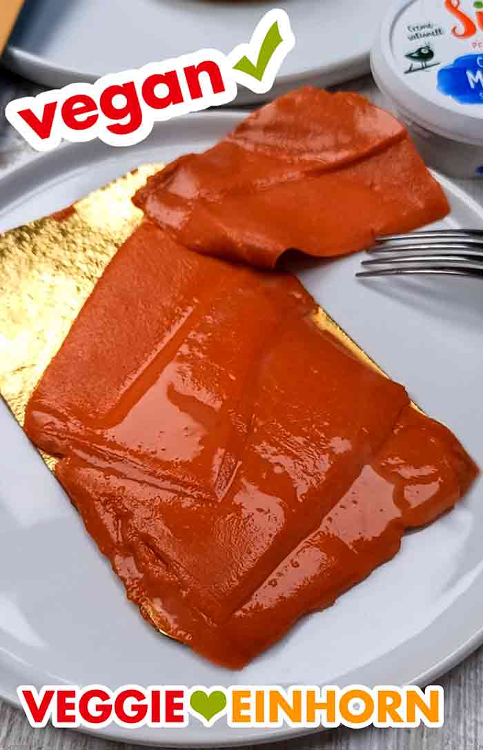 So sieht der Veganz Räucherlachs aus. 4 Scheiben veganer Lachs auf einer goldfarbenen Pappe