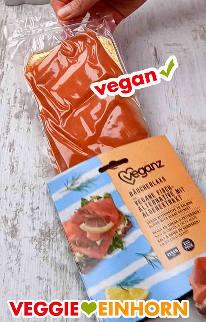 Der Veganz Räucherlachs ist in Pappe und Plastikfolie verpackt. Der vegane Lachs auf einer goldfarbenen Pappe und in Folie eingeschweißt