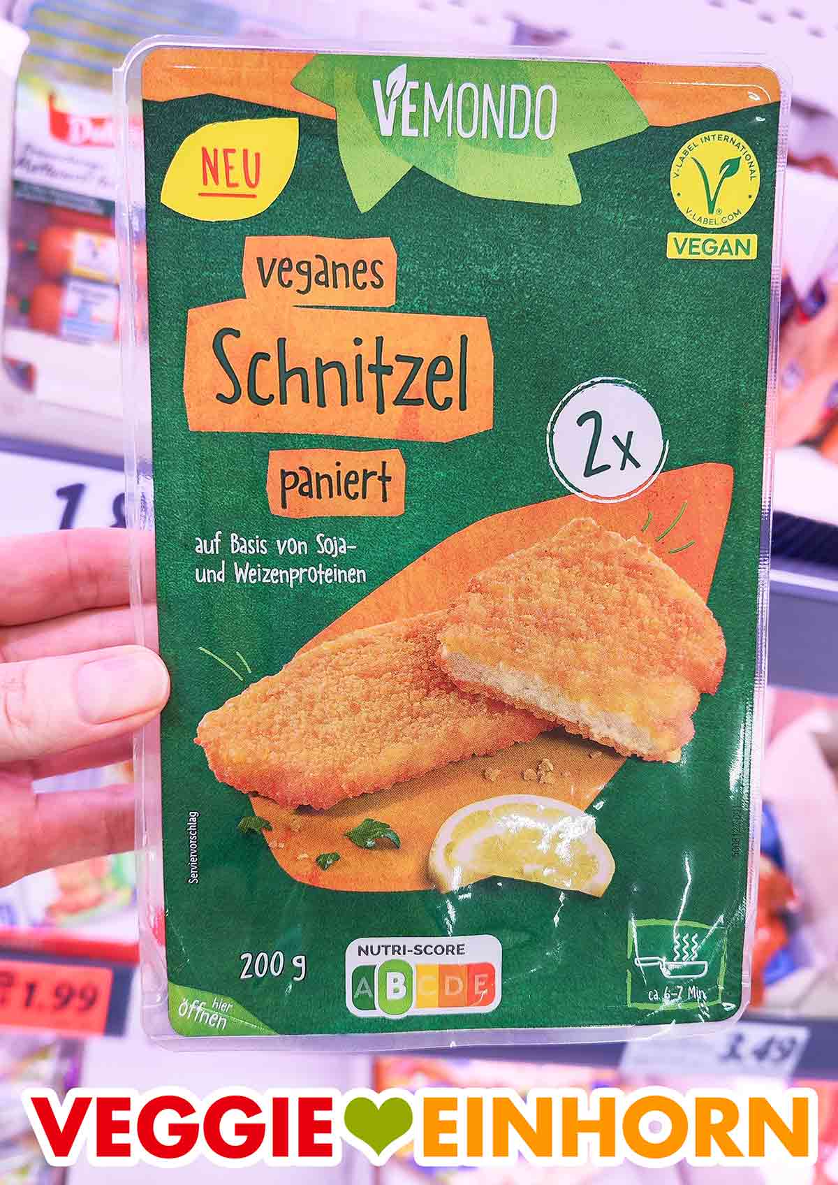In der Packung sind zwei vegane Schnitzel. Eine Hand hält eine Packung Vemondo Schnitzel im Lidl