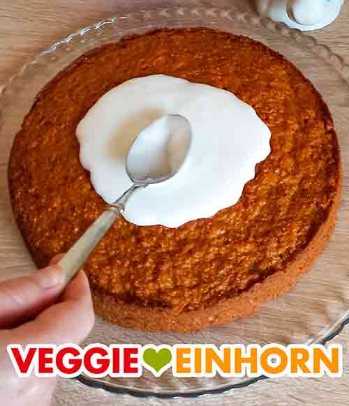 Verteilen des Zuckerguss mit einem Löffel. Der Zuckerguss wird mit einem Esslöffel auf dem Kuchen verteilt.