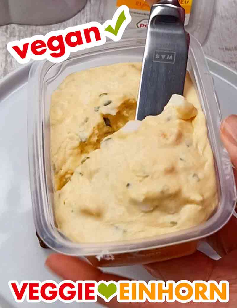 Der vegane Eiersalat von Popp Feinkost enthält Mayonnaise und Eiersatz Veganer Eiersalat in der geöffneten Packung mit einem Messer
