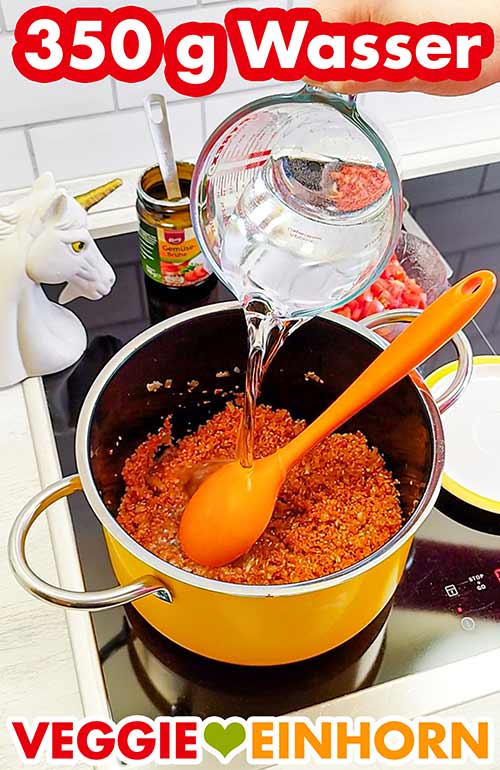 Zufügen von 350 g Wasser für den Tomatenbulgur Wasser wird aus einem Messbecher in den Topf gegossen