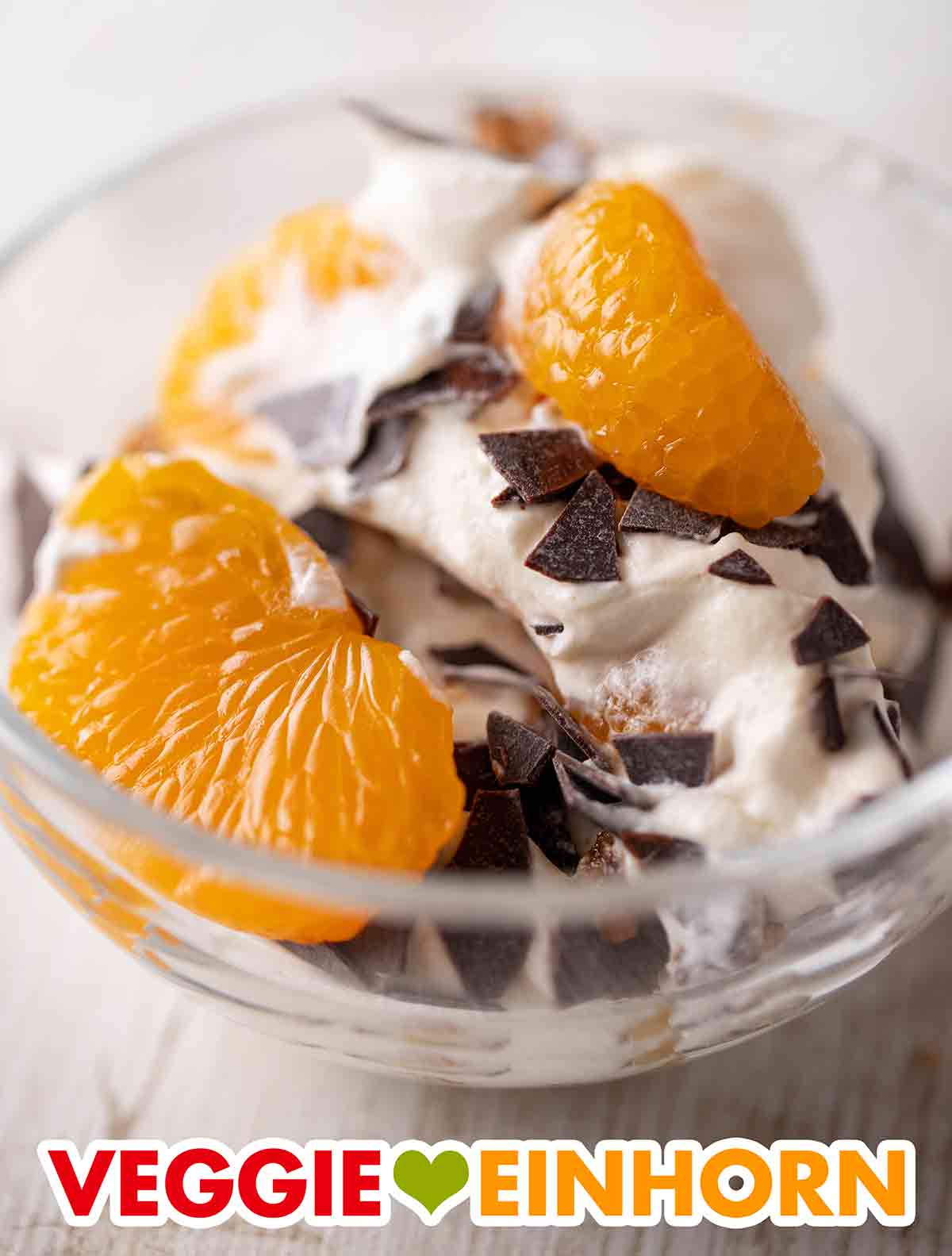 Der vegane Nachtisch kommt an Weihnachten sehr gut an. Nahaufnahme einer Dessertschale mit veganem Weihnachtsdessert mit Mandarinen und Lebkuchen