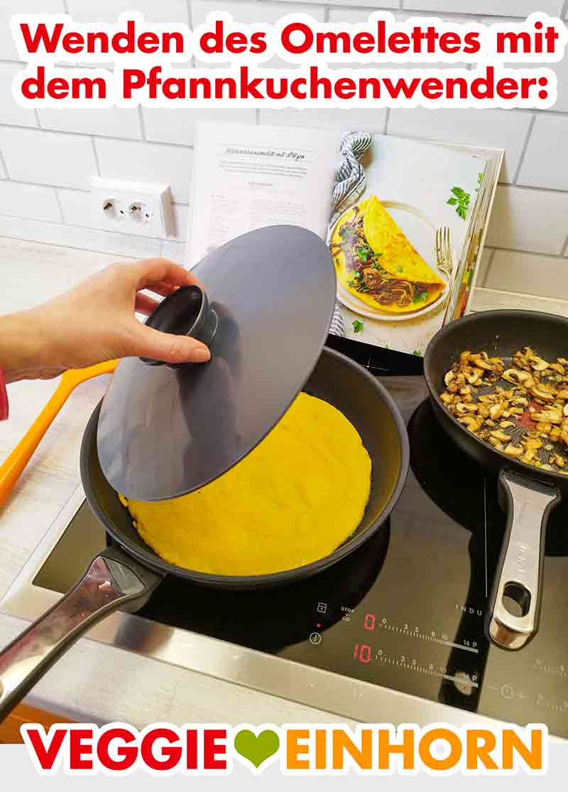 Das vegane Omelett soll mit dem Pfannkuchenwender gewendet werden. Der Pfannkuchenwender über der Pfanne mit dem veganen Omelett