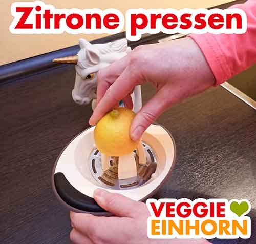 Zitrone auspressen Eine halbe Zitrone wird mit einer Zitruspresse ausgepresst
