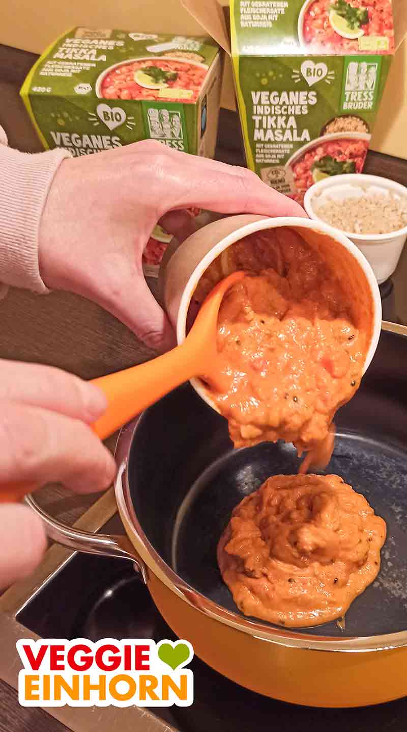 Das vegane indische Tikka Masala wird im Topf zubereitet. Der Becher Tikka Masala wird in den Topf gegeben.