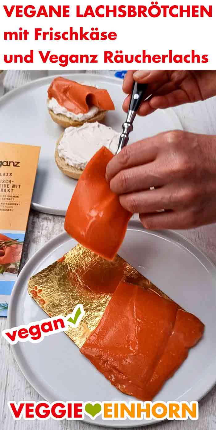 Zubereitung eines veganen Lachsbrötchens Eine Scheibe veganer Lachs wird auf ein Brötchen mit Frischkäse gelegt.