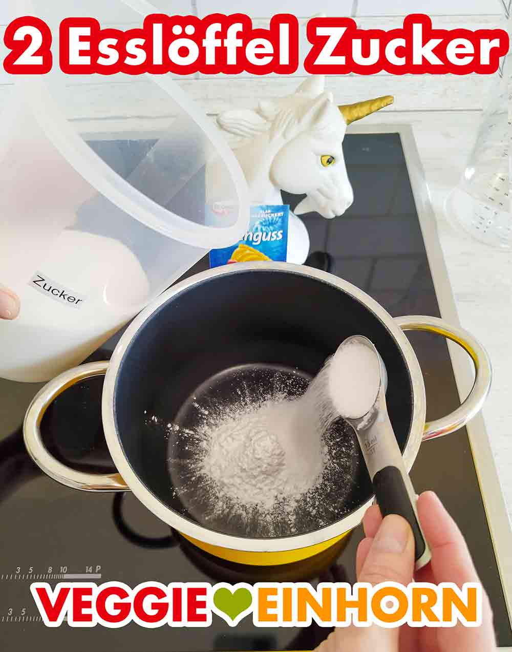 Das Tortenguss Pulver ist ungezuckert. Deswegen geben wir 2 Esslöffel Zucker dazu. Zwei Esslöffel Zucker werden zum Tortenguss Pulver zugefügt.