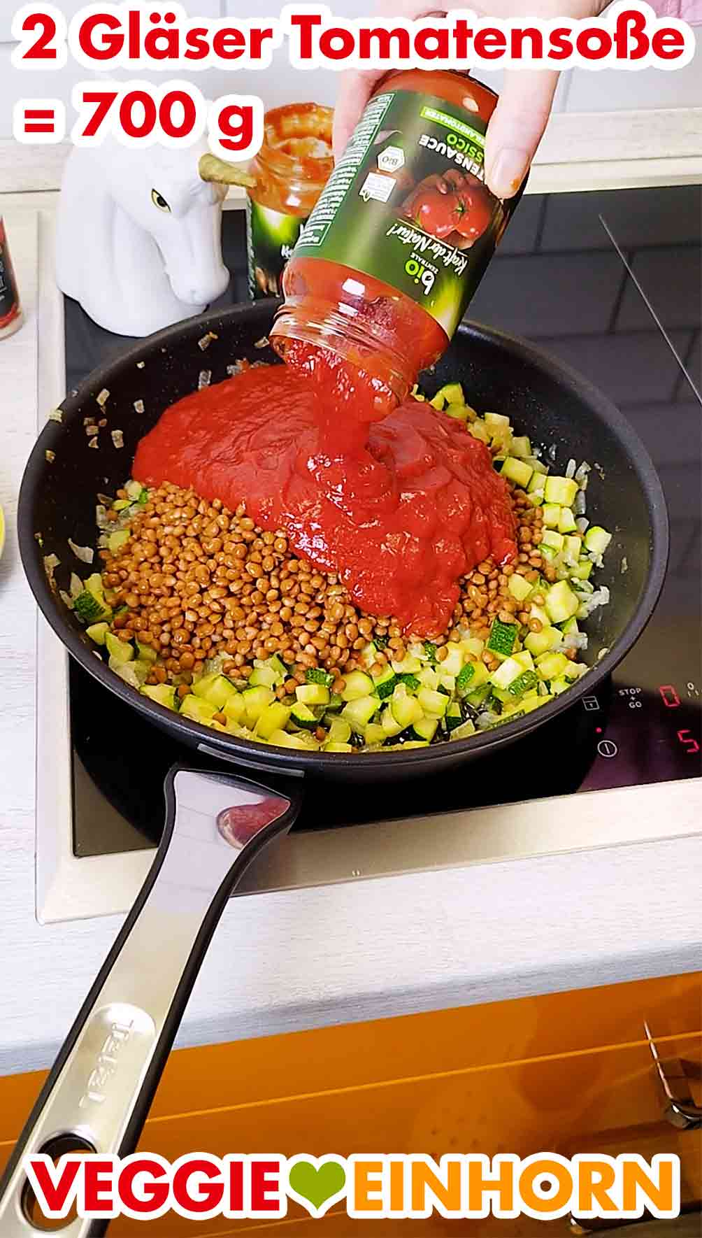 Du brauchst zwei Gläser fertig gewürzte Tomatensauce mit Kräutern. Vegane Tomatensoße aus dem Glas wird in die Pfanne gegeben