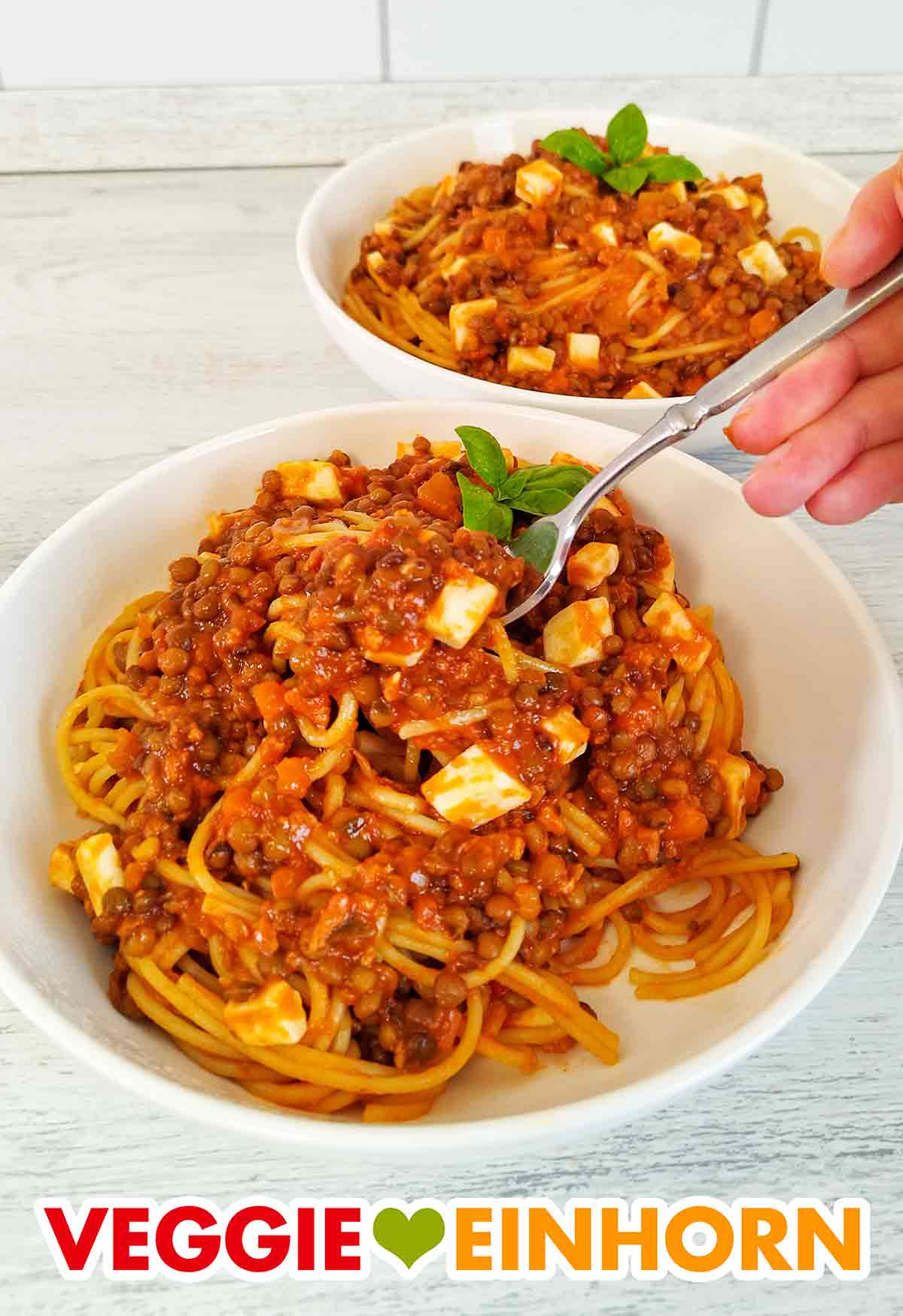 Das vegane Nudelgericht gelingt mit Spaghetti oder anderen Nudeln. Zwei Teller Nudeln mit Soja Bolognese, veganem Feta und Linsen