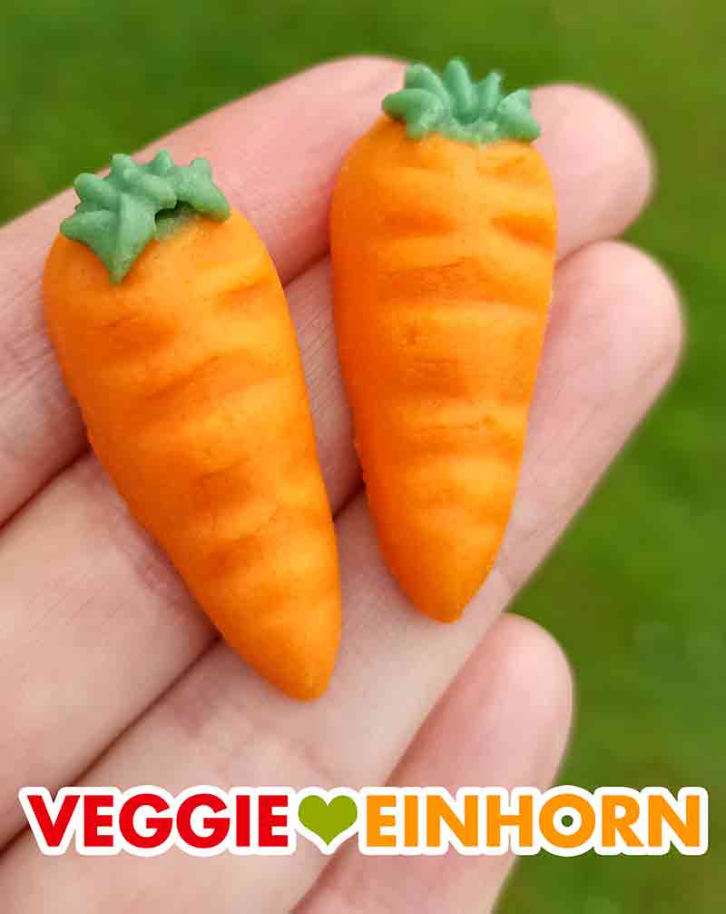 Die veganen Marzipan Karotten schmecken sehr gut. Zwei vegane Marzipankarotten von Odenwälder auf einer Hand