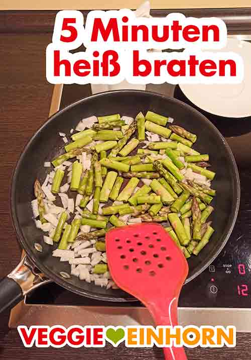 Zwiebelwürfel und grünen Spargel 5 Minuten heiß braten. Zwiebeln und grüner Spargel braten in der Pfanne.