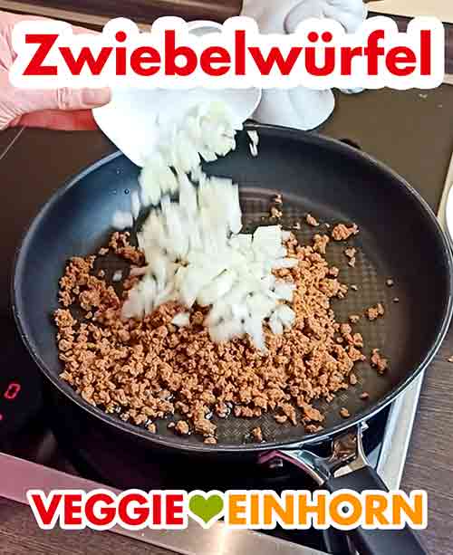 Zufügen der Zwiebel Zwiebelwürfel werden zu dem Hack in die Pfanne gegeben